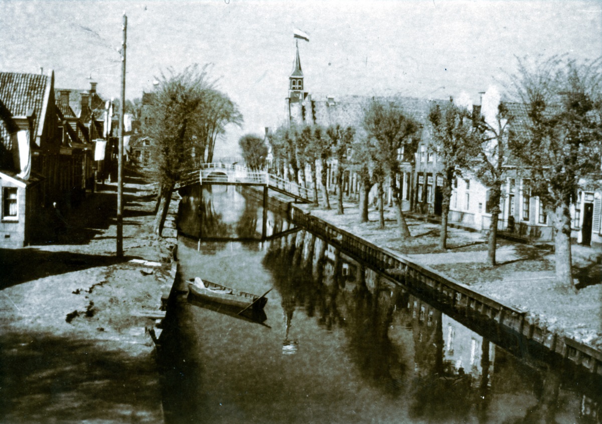 Foto van Sloten aan het eind van de oorlog.  De foto is gemaakt door Tjipke de Jong. Achterop heeft hij geschreven: “Onze stad ziet er na 5 jaar van weinig onderhoud haveloos uit.”  Sloten was een ‘noodlijdende gemeente’, en er was inderdaad geen geld voor dergelijk onderhoud van wegen en gebouwen. Er was altijd geld te weinig (ook in de eerste jaren van de oorlog toen de schaarste aan materialen nog niet zo nijpend was en elders nog wel aan onderhoud kon worden gedaan). Documenten uit het oorlogsarchief van Sloten getuigen van het eeuwige geldgebrek.